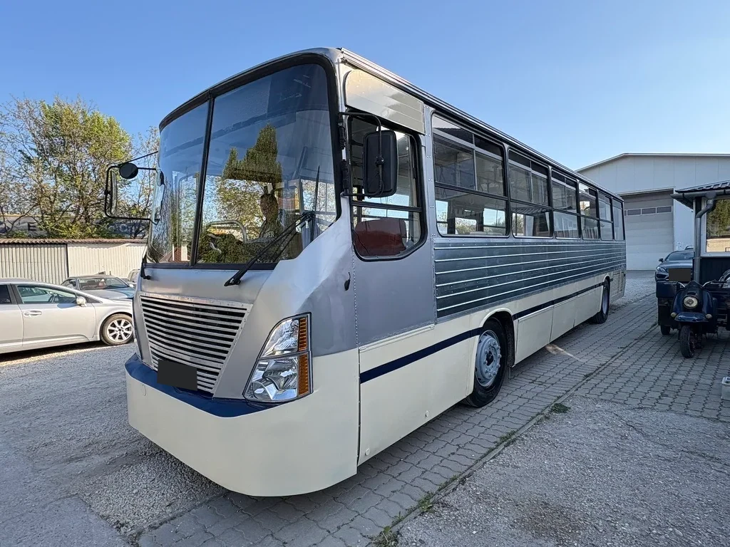 Silver and white converted bus photographed outdoors