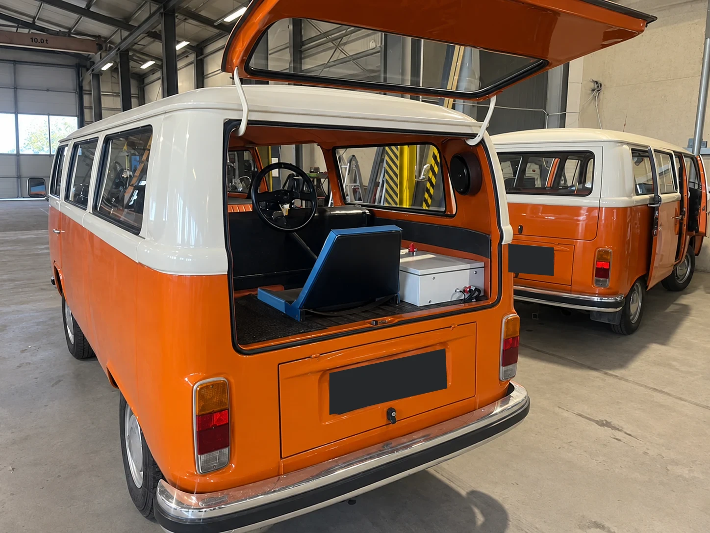 Narancssárga Volkswagen T2, a nyitott hátsó ajtó mögött kialakított rejtett vezetőállással